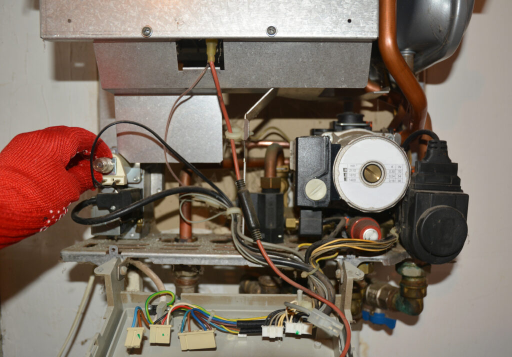 Close up of HVAC technician repairing a boiler